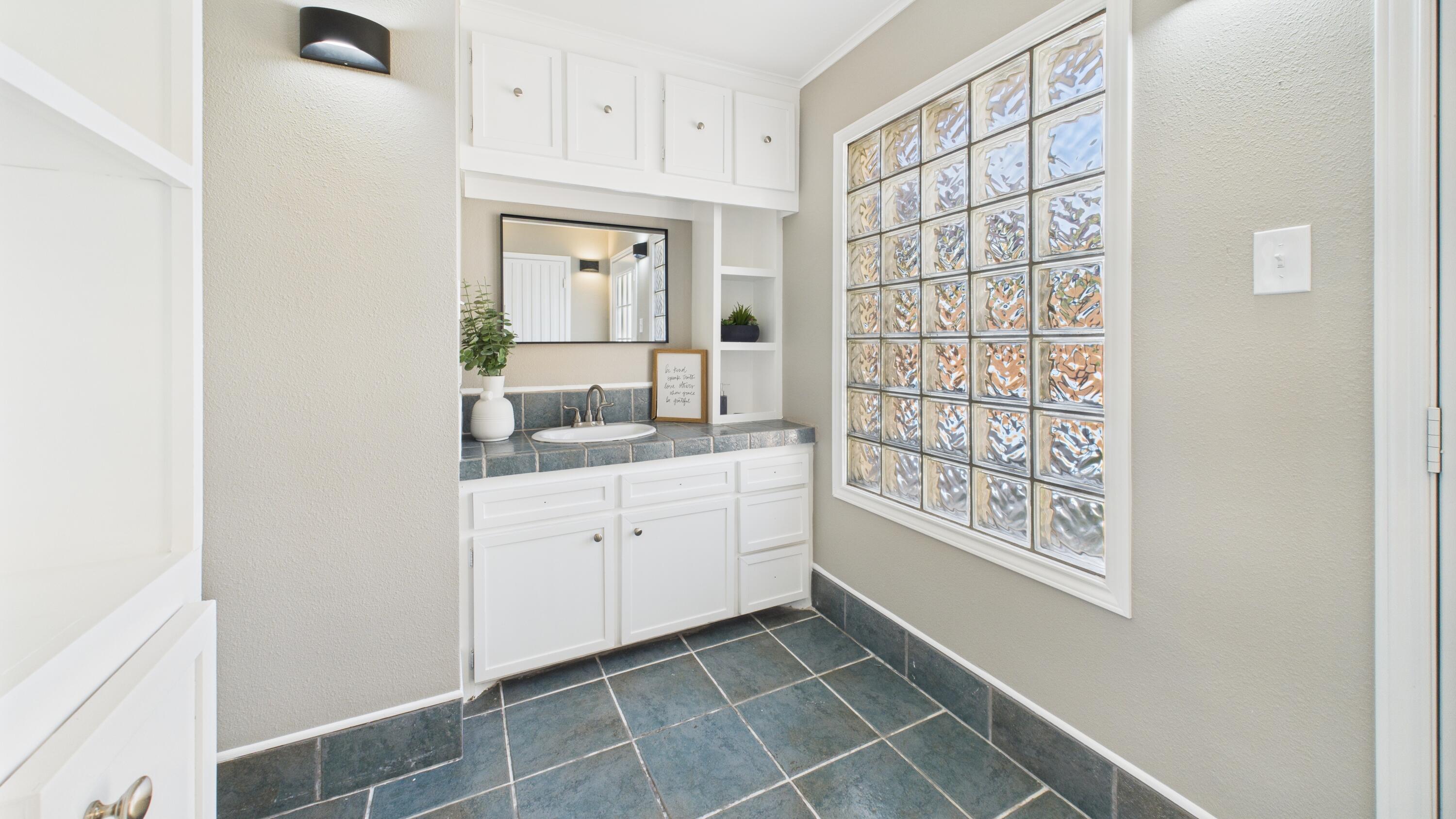 5719 2nd Street Lubbock, TX 79416 - Photo 46 of 61 a bathroom with a granite countertop sink and a mirror