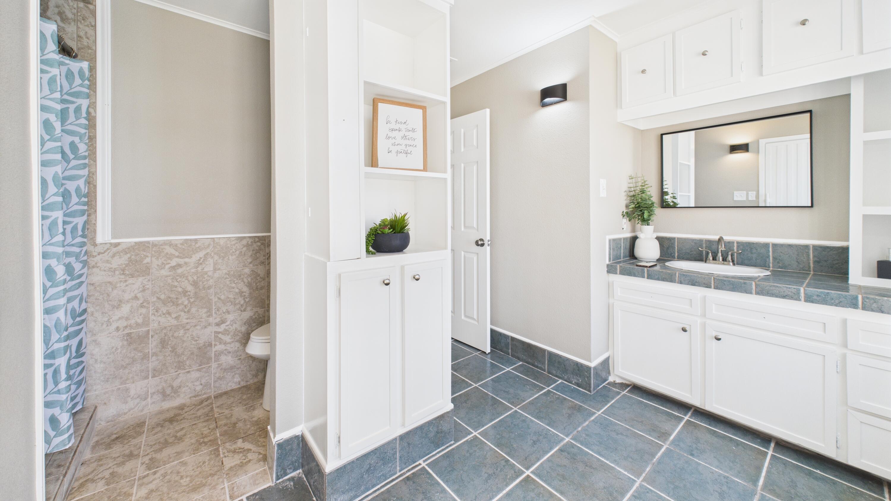 5719 2nd Street Lubbock, TX 79416 - Photo 49 of 61 a bathroom with a granite countertop sink and a mirror