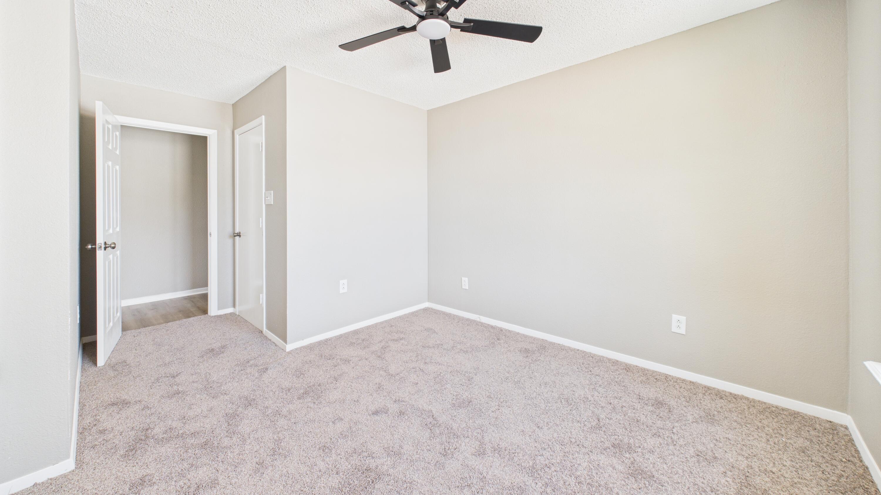 5719 2nd Street Lubbock, TX 79416 - Photo 52 of 61 an empty room with a ceiling fan and carpet