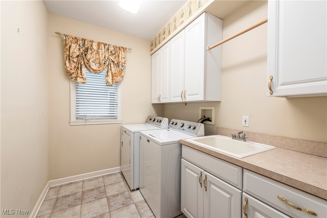 455 Old Reservoir Road Berea, OH 44017 - Photo 27 of 49 Clothes washing area with washer and clothes dryer, cabinets, and sink