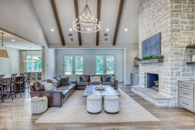 a living room with furniture a fireplace and a chandelier
