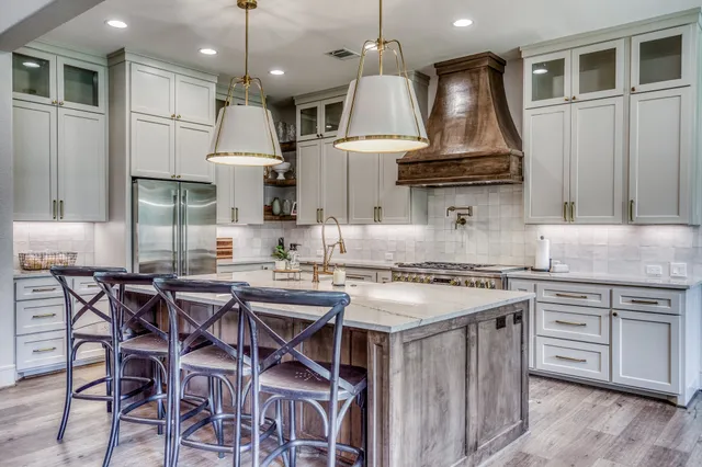 a kitchen with stainless steel appliances granite countertop a stove a sink and a refrigerator