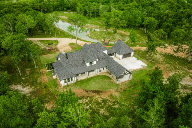 an aerial view of a house with a yard basket ball court and outdoor seating