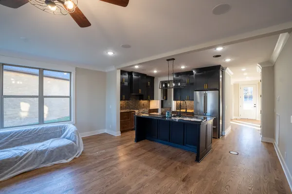 a kitchen with kitchen island granite countertop wooden cabinets and a refrigerator