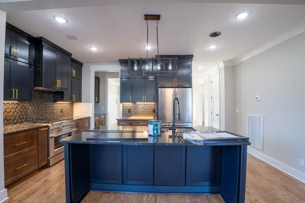 a kitchen with stainless steel appliances granite countertop a stove and a refrigerator