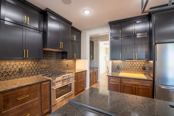 a kitchen with stainless steel appliances granite countertop a sink a stove and a wooden floors