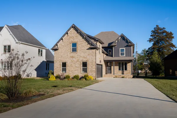 a view of a white house with a big yard and potted plants