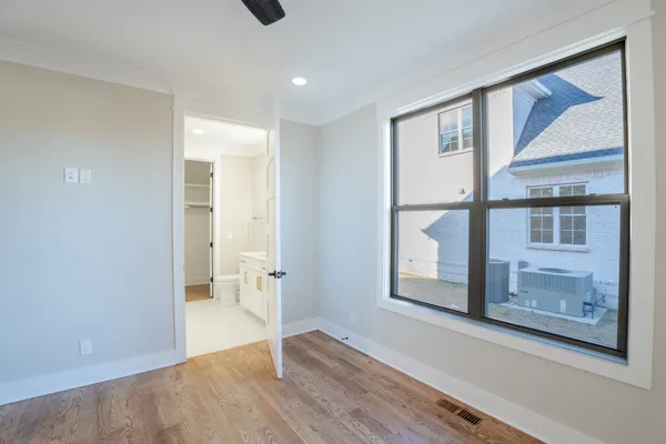 a view of hallway with a large window and wooden floor