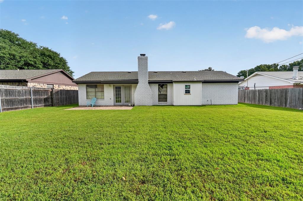 1212 Manning Road Benbrook, TX 76126 - Photo 17 of 20 Expansive backyard featuring a manicured lawn, full privacy fencing, and a white brick exterior