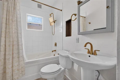 a bathroom with a sink toilet and a mirror