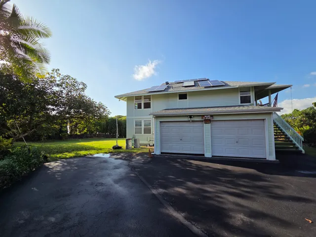 an aerial view of a house with a yard and lake view