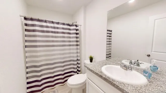 a bathroom with a sink toilet and shower