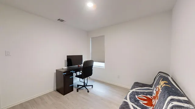 a view of a workspace with furniture and a window