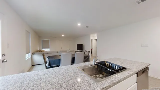 a kitchen that has a sink a counter top space and stainless steel appliances