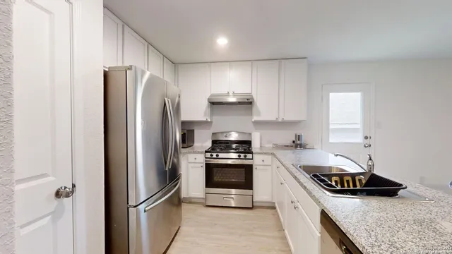 a kitchen with stainless steel appliances granite countertop a stove and a refrigerator