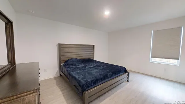 a bed sitting in a bedroom next to a window