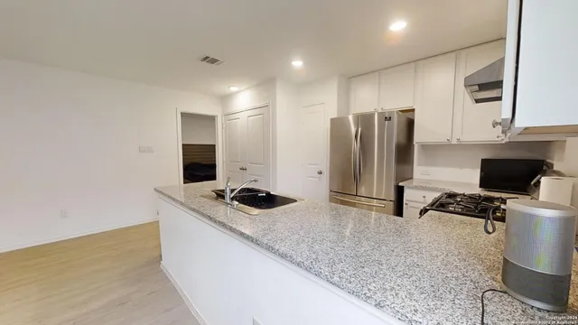 a kitchen with stainless steel appliances granite countertop a sink stove and refrigerator