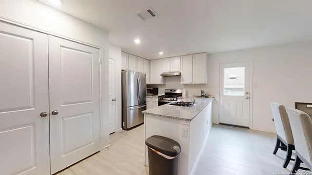 a kitchen with a refrigerator a stove top oven a sink and dishwasher