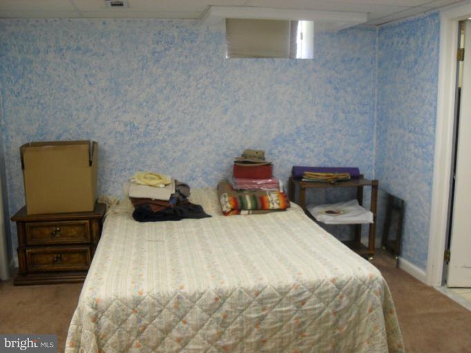 14309 Ansted Road Silver Spring, MD 20905 - Photo 11 of 17 a bedroom with a bed and wooden floor