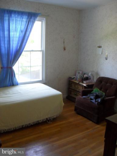 14309 Ansted Road Silver Spring, MD 20905 - Photo 4 of 17 a bedroom with a bed and wooden floor