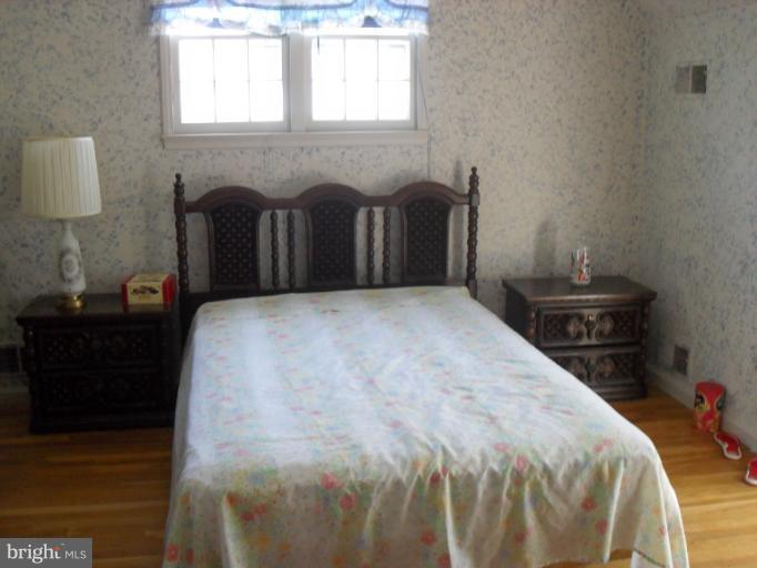 14309 Ansted Road Silver Spring, MD 20905 - Photo 7 of 17 a bed sitting in a bedroom next to a window