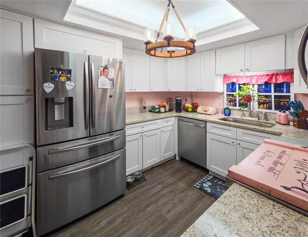 a kitchen with stainless steel appliances a sink cabinets and wooden floor