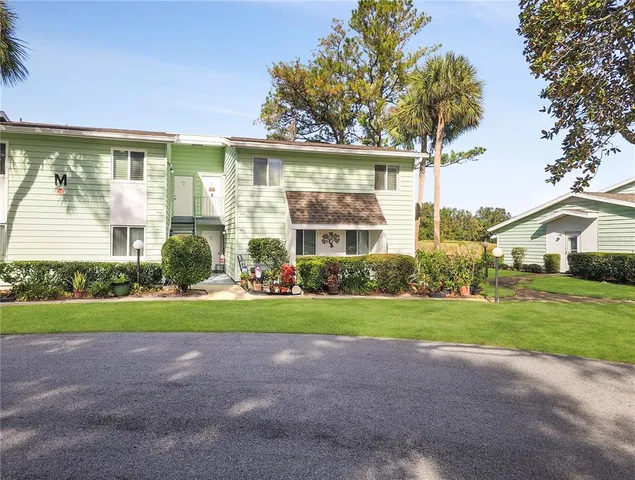 a front view of a house with a yard and trees