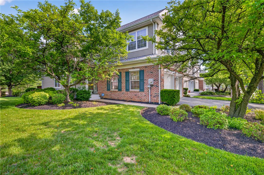 4345 Creek Road Allentown, PA 18104 - Photo 2 of 33 A classic brick and siding home, nestled amidst mature trees and vibrant landscaping, features a neat lawn and an attached garage.