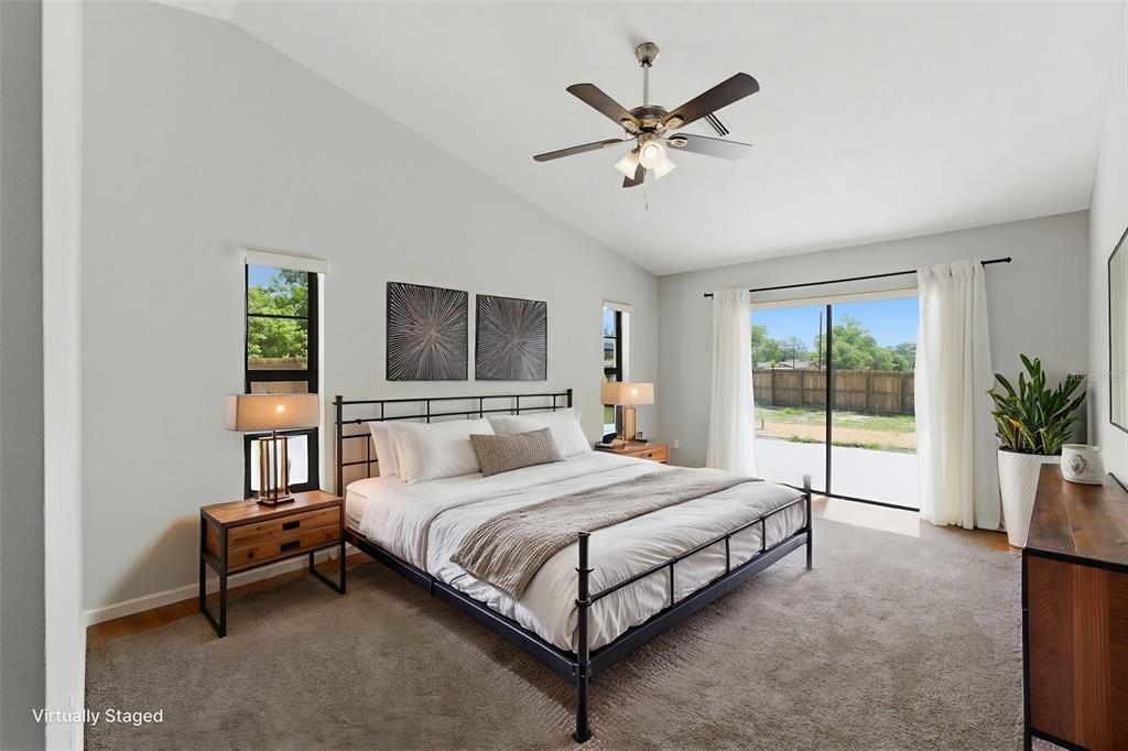 4966 Keysville Avenue Spring Hill, FL 34608 - Photo 25 of 48 a bedroom with a large bed and a chandelier
