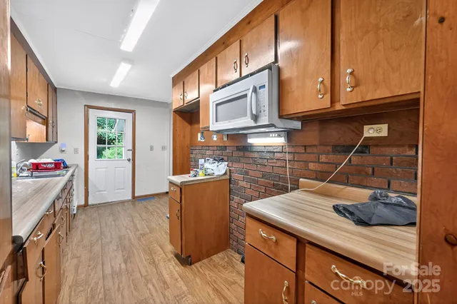 a kitchen with a sink a stove cabinets and wooden floor