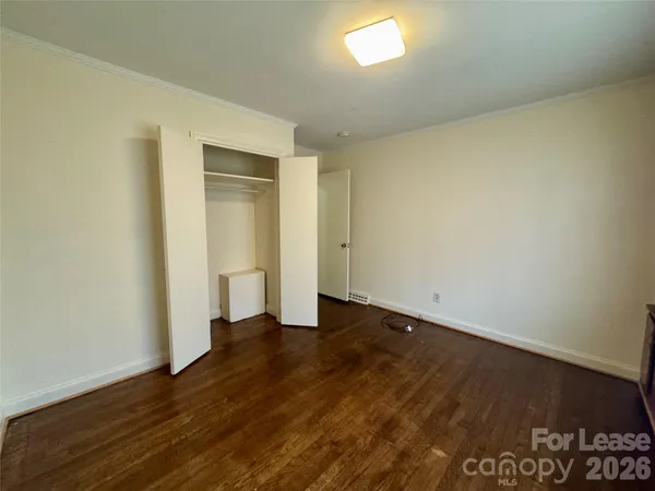 an empty room with wooden floor and closet