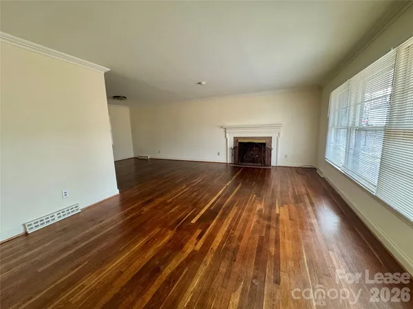 a view of empty room with wooden floor and fireplace