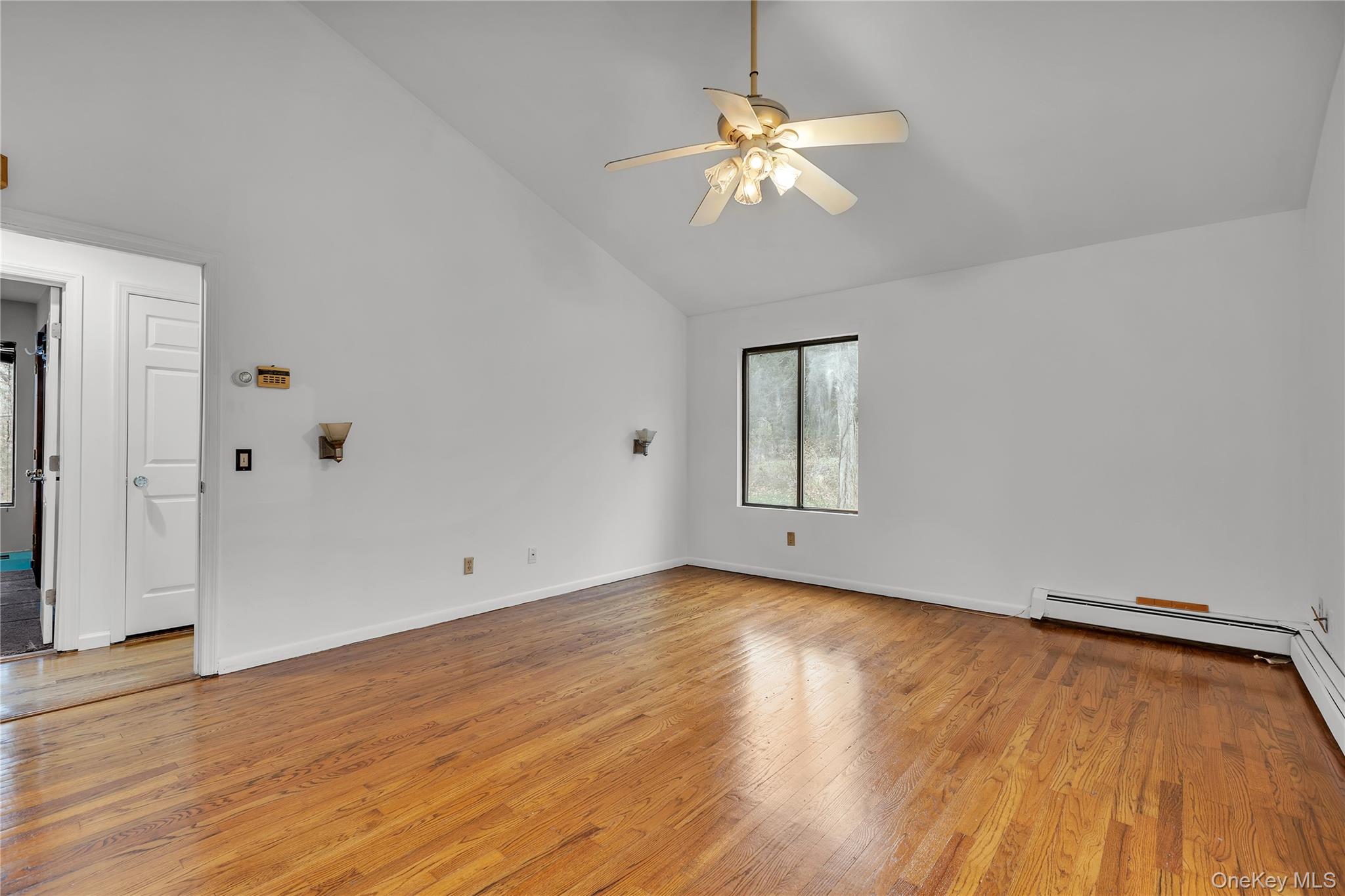 1845 Jacob Road Cortlandt Manor, NY 10567 - Photo 13 of 38 an empty room with wooden floor chandelier fan and windows