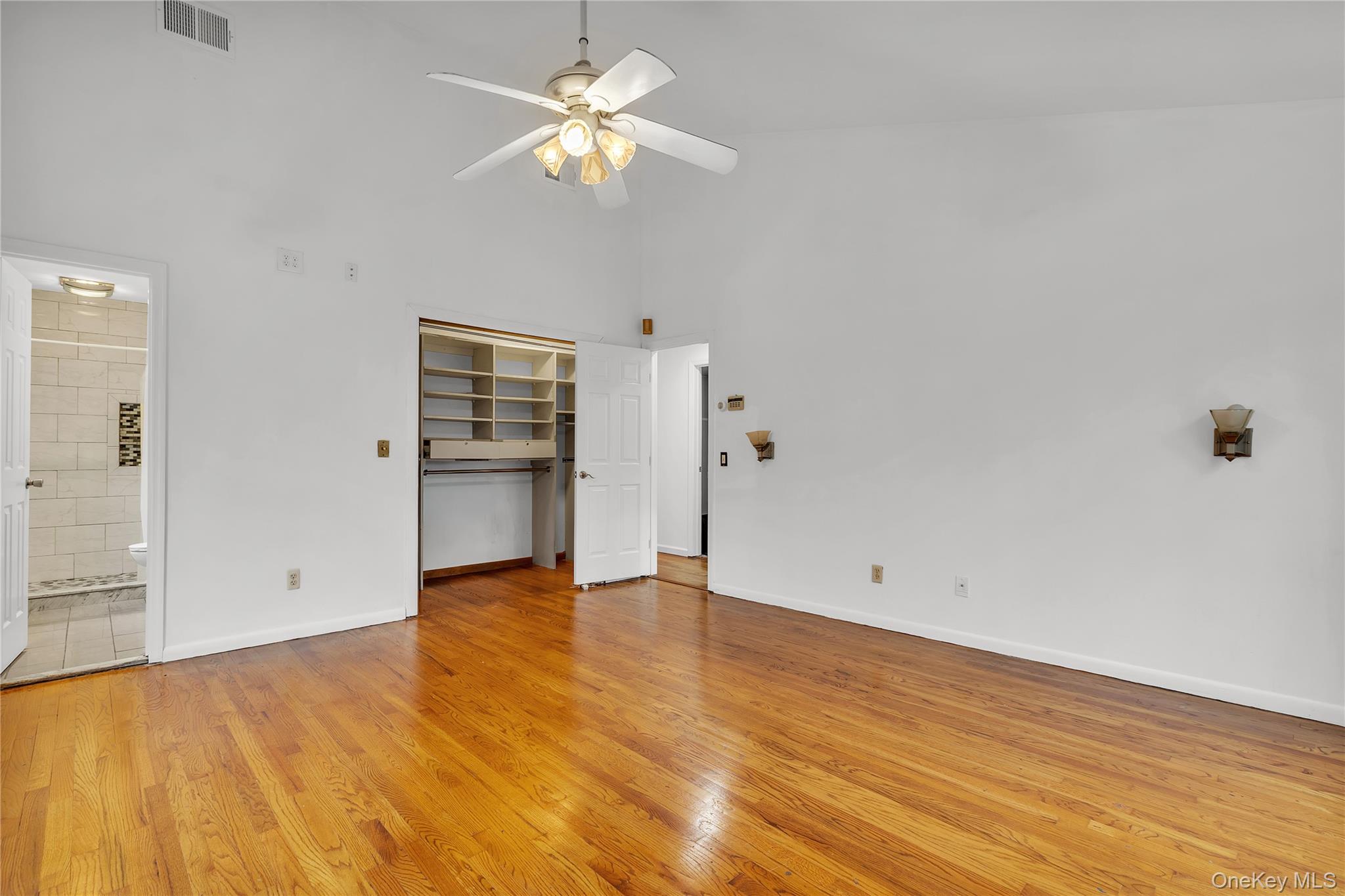 1845 Jacob Road Cortlandt Manor, NY 10567 - Photo 16 of 38 an empty room with wooden floor chandelier fan and windows