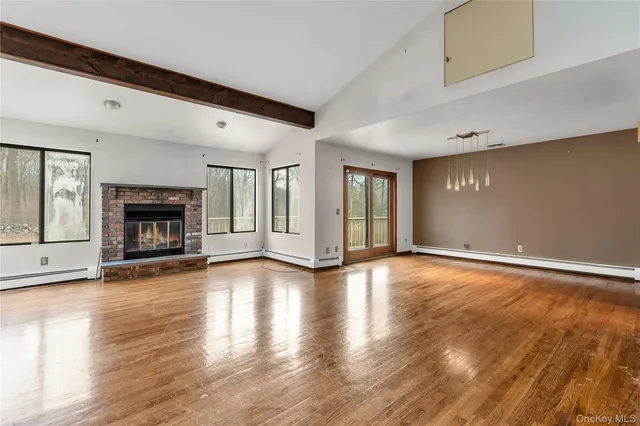 a view of an empty room with window and fire place