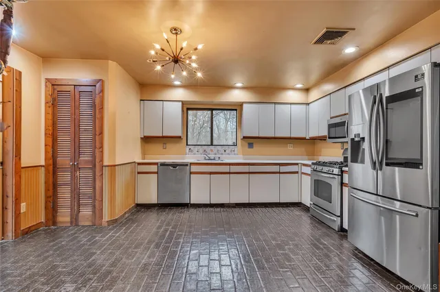 a kitchen with a refrigerator sink and cabinets