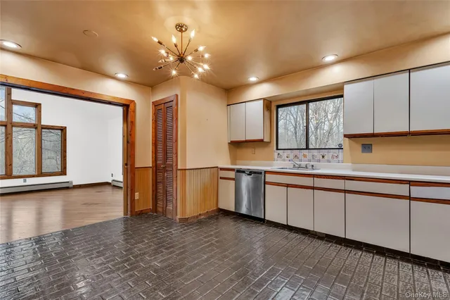 a kitchen with granite countertop a sink cabinets and stainless steel appliances