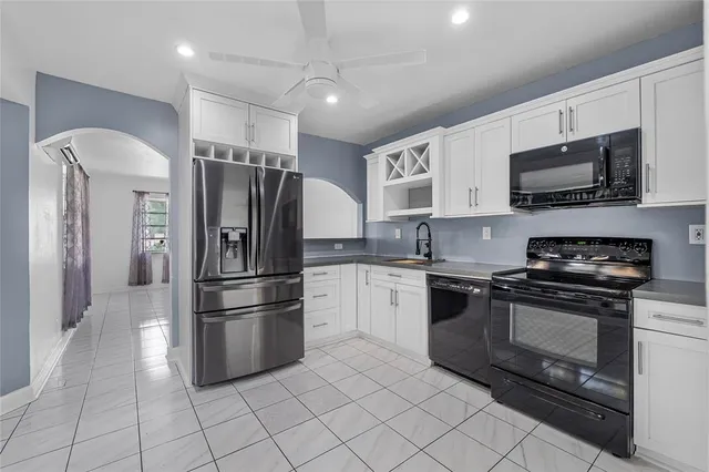 a kitchen with stainless steel appliances granite countertop a refrigerator sink and stove