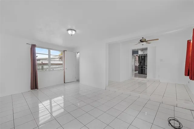 a view of an empty room with window and cabinet