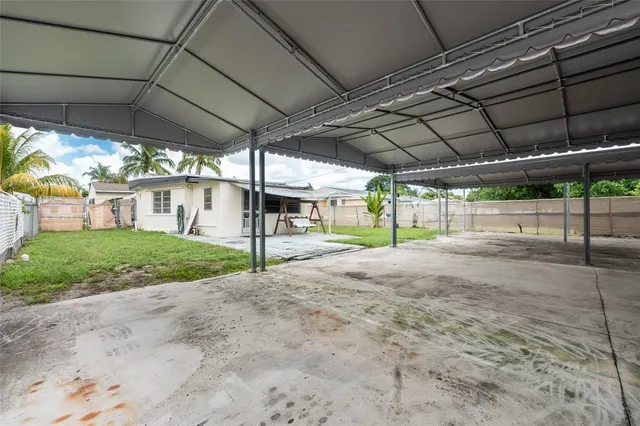 a view of a backyard with table and chairs under an umbrella