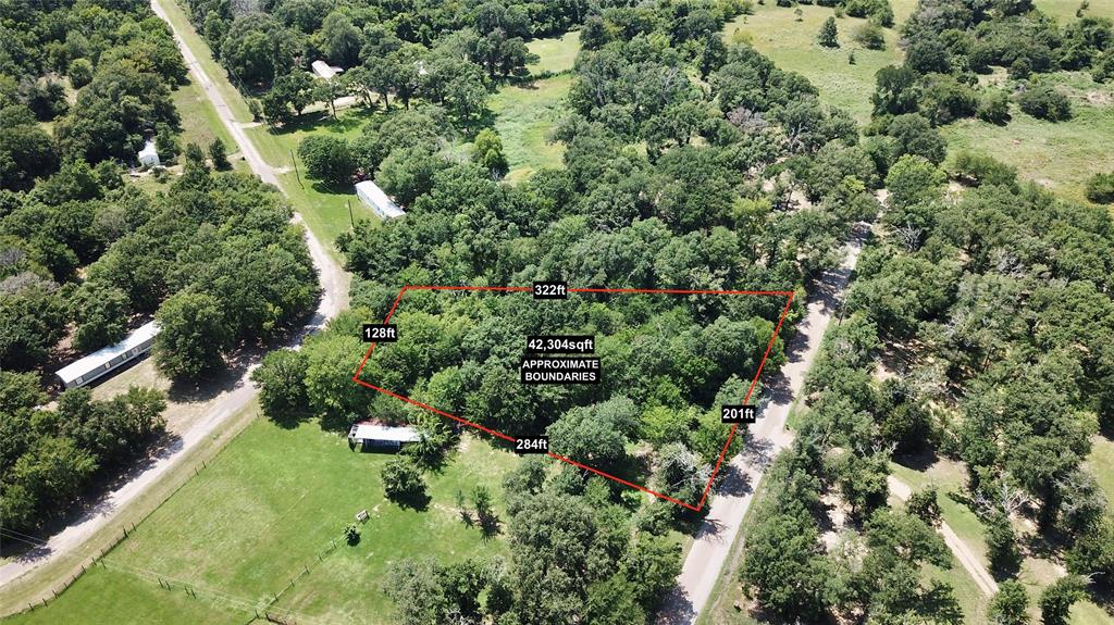 an aerial view of residential house with outdoor space and trees all around