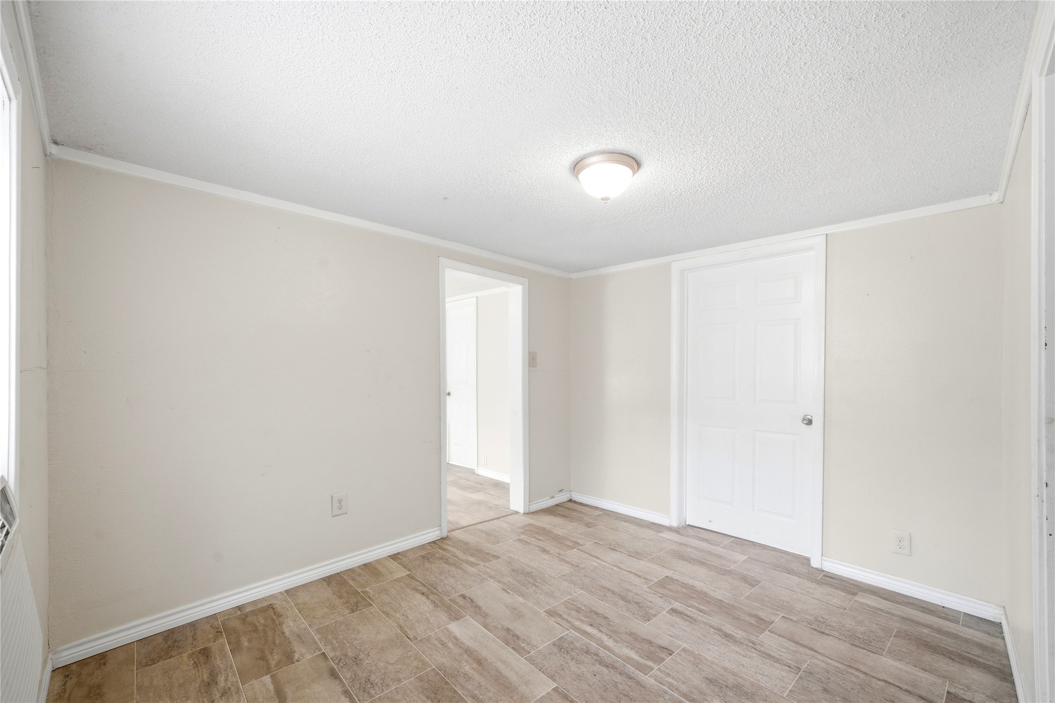 101 Outlar Street Wharton, TX 77488 - Photo 7 of 40 an empty room with wooden floor and windows