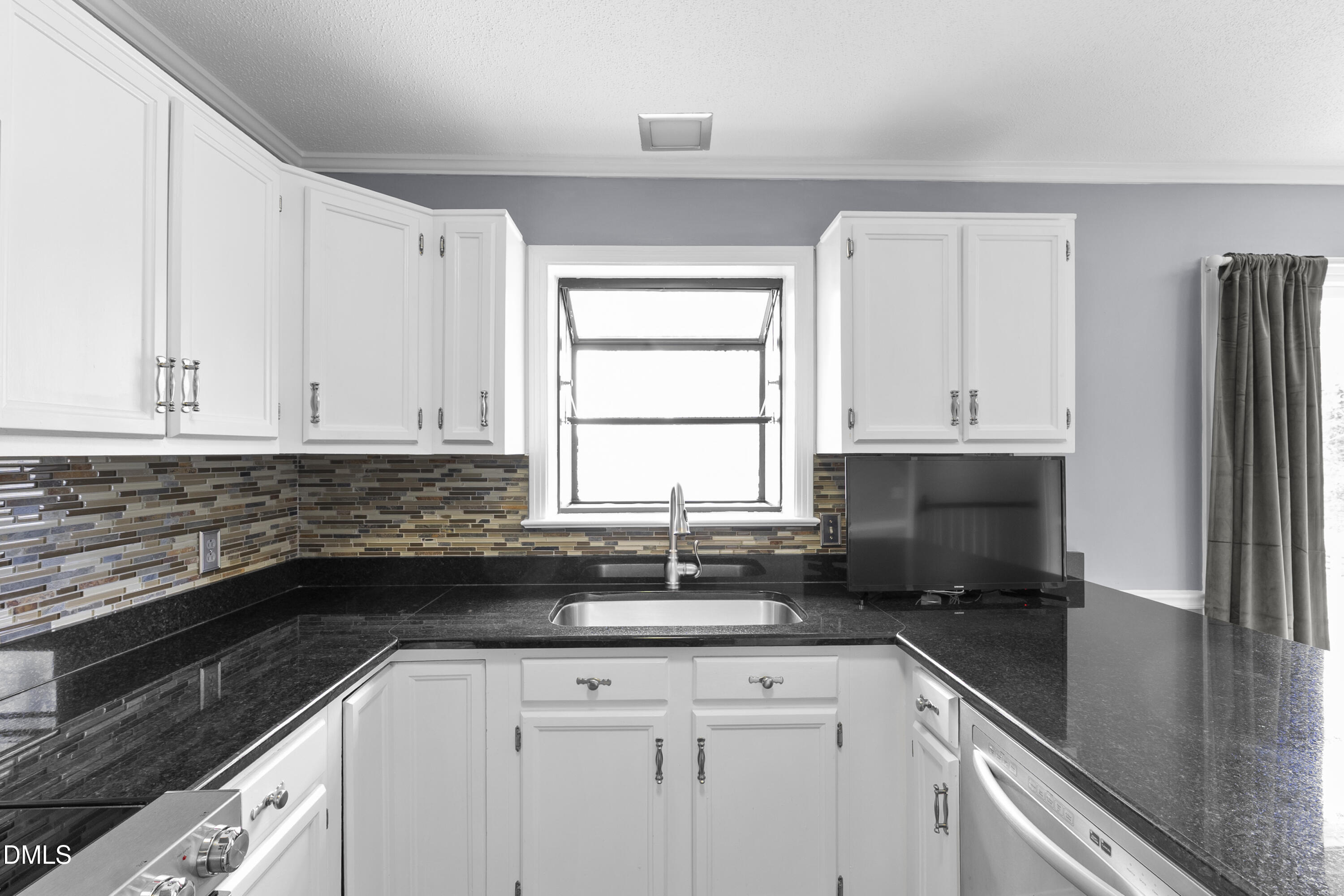 1821 Owls Nest Road Sanford, NC 27330 - Photo 39 of 77 a kitchen with granite countertop white cabinets and black appliances
