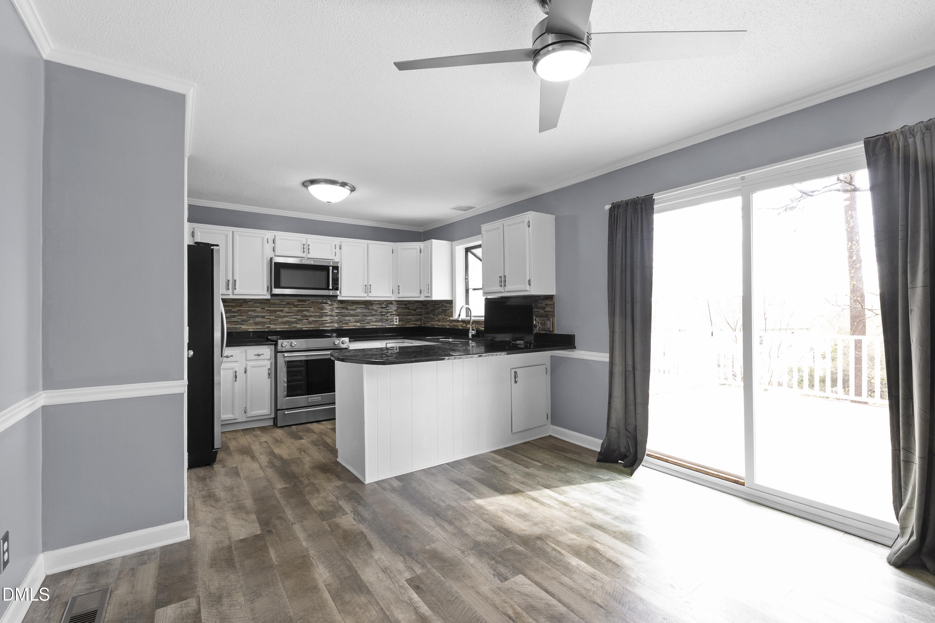 1821 Owls Nest Road Sanford, NC 27330 - Photo 42 of 77 a kitchen with granite countertop a refrigerator and white cabinets