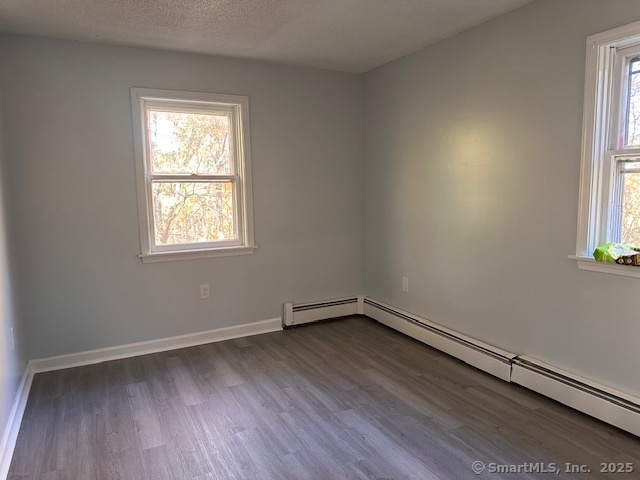 259 Westchester Road, Unit A Colchester, CT 06415 - Photo 12 of 24 an empty room with wooden floor and windows