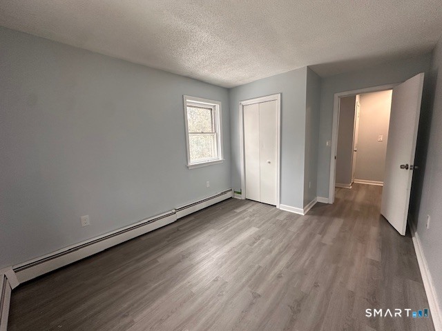 259 Westchester Road, Unit A Colchester, CT 06415 - Photo 13 of 24 an empty room with wooden floor and windows