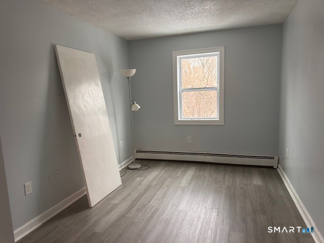 259 Westchester Road, Unit A Colchester, CT 06415 - Photo 15 of 24 an empty room with wooden floor and windows