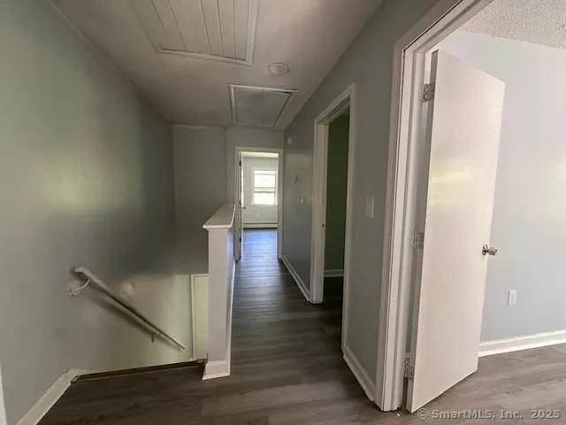 a view of hallway with stairs and wooden floor