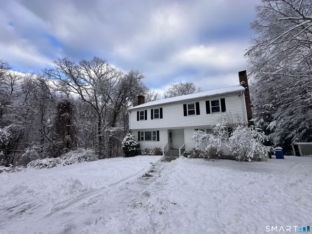 a view of a house with a yard covered in snow
