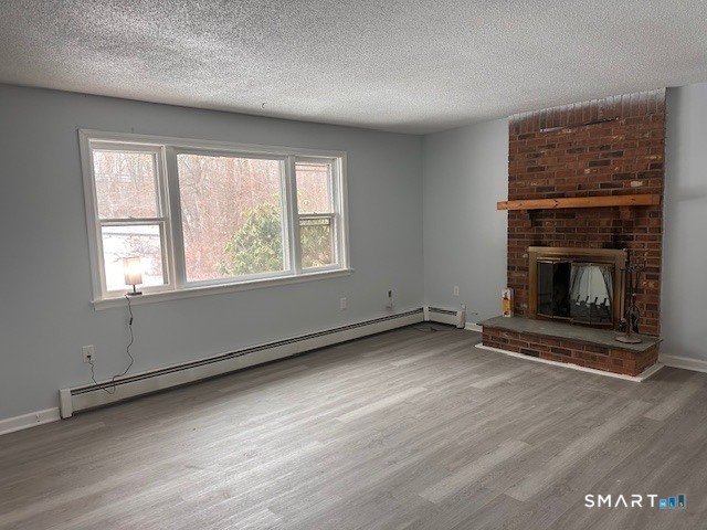 259 Westchester Road, Unit A Colchester, CT 06415 - Photo 4 of 24 an empty room with wooden floor fireplace and windows